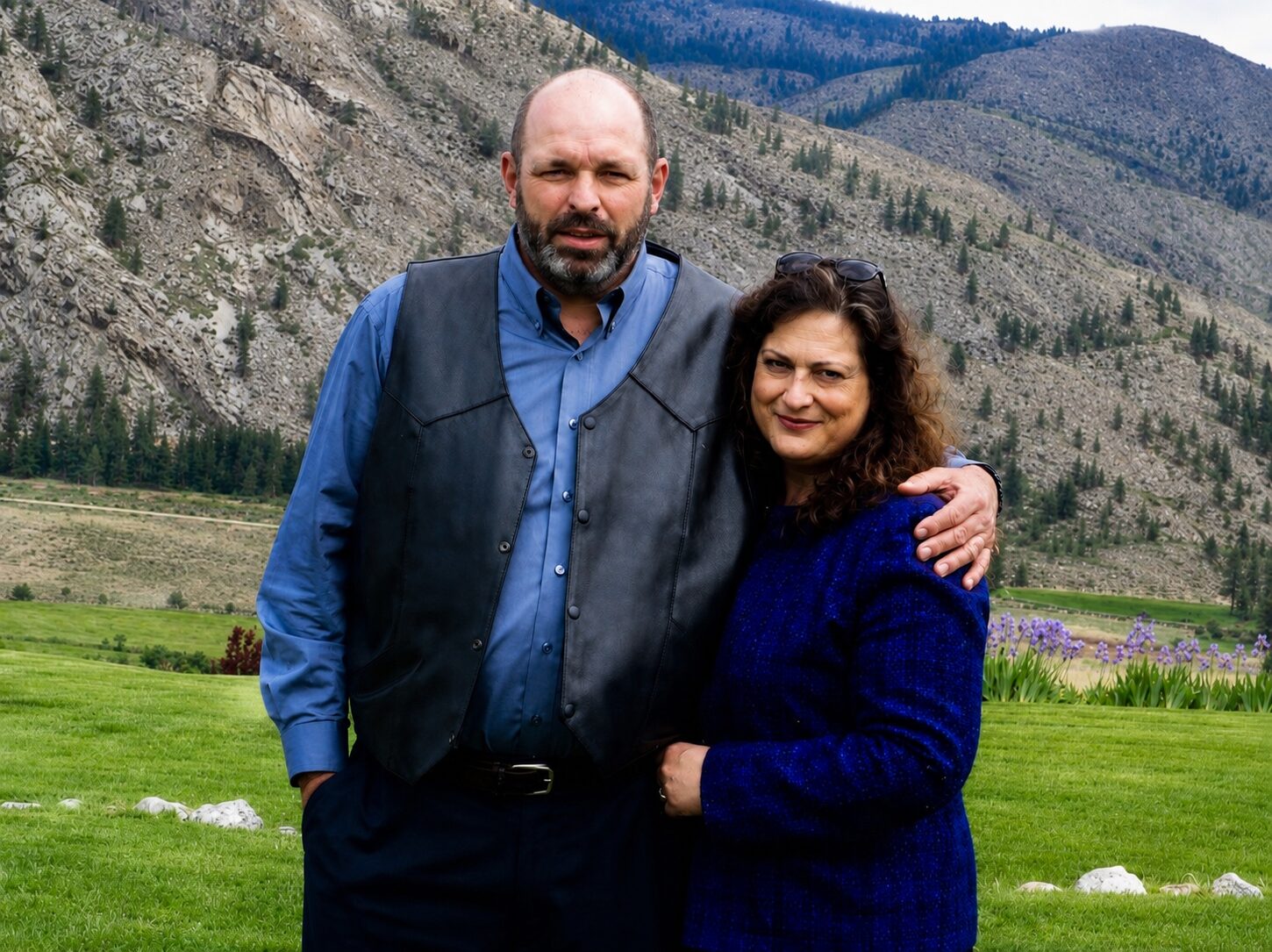 John and Lorrie Cox standing together in front of the mountains